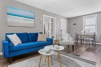a living room with a blue couch and a table at KING Bed Entire House Near DT in Cleveland