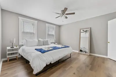 a white bedroom with a bed and a ceiling fan at KING Bed Entire House Near DT in Cleveland