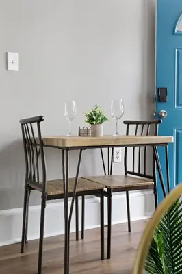 a wooden table with two wine glasses and two chairs at Trendy Ohio City Parking Wifi Mins to DT in Cleveland