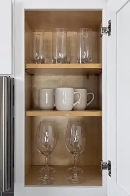 two wine glasses and bowls on a shelf in a kitchen at Trendy Ohio City Parking Wifi Mins to DT in Cleveland
