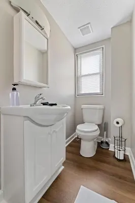a white bathroom with a sink and a toilet at Trendy Ohio City Parking Wifi Mins to DT in Cleveland