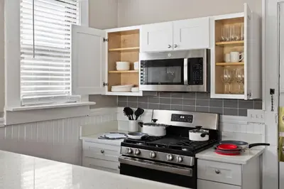 a white kitchen with a stove and a microwave at Trendy Ohio City Parking Wifi Mins to DT in Cleveland