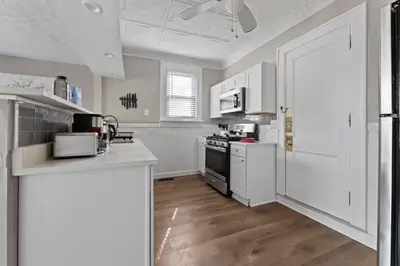 a kitchen with white cabinets and a stove top oven at Trendy Ohio City Parking Wifi Mins to DT in Cleveland