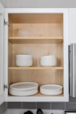 a cupboard with plates and bowls in it at Trendy Ohio City Parking Wifi Mins to DT in Cleveland