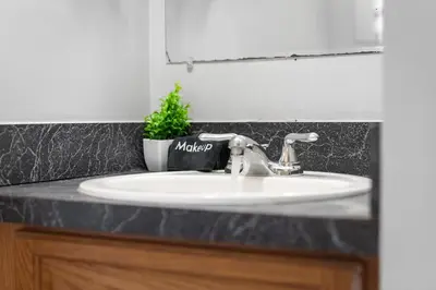 a bathroom counter with a sink and a mirror at Little Italy Family Suite 4 TVs Bunk Beds in Cleveland