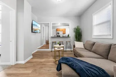 a living room with a couch and a table at Little Italy Family Suite 4 TVs Bunk Beds in Cleveland