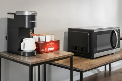 a microwave and a coffee maker on a table at King Bed 2 TVs Fast Wifi Pet Friendly! in Cleveland