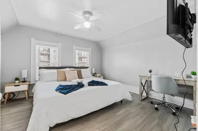 a bedroom with a bed and a desk and a television at King Bed 2 TVs Fast Wifi Pet Friendly! in Cleveland