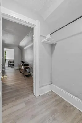 an empty living room with a white wall and a hallway at King Bed 2 TVs Fast Wifi Pet Friendly! in Cleveland