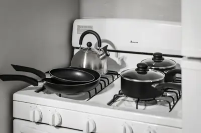 two pots and a tea kettle on a stove at King Bed 2 TVs Fast Wifi Pet Friendly! in Cleveland