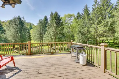 a large wooden deck with a grill on it at 23 Mi to Mohican SP Group-Ready Lodge with Hot Tub in Brinkhaven
