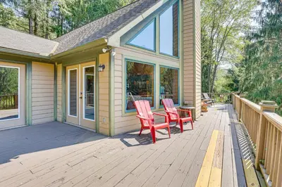 a porch with two chairs and a table on it at 23 Mi to Mohican SP Group-Ready Lodge with Hot Tub in Brinkhaven