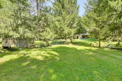 a park with a bench in a field with trees at 23 Mi to Mohican SP Group-Ready Lodge with Hot Tub in Brinkhaven