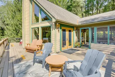 a patio with chairs and a table on a deck at 23 Mi to Mohican SP Group-Ready Lodge with Hot Tub in Brinkhaven
