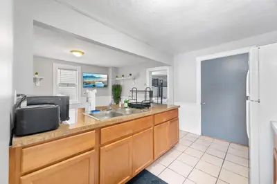 a kitchen with a sink and a refrigerator at Little Italy Group Stay 4 TV's Pet Friendly in Cleveland