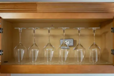a row of wine glasses sitting on a shelf at Little Italy Group Stay 4 TV's Pet Friendly in Cleveland
