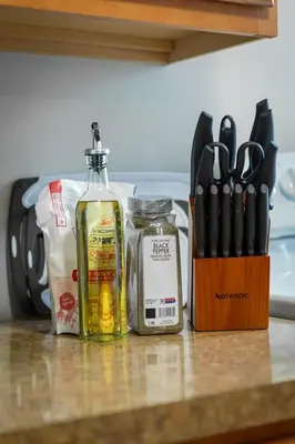 a kitchen counter with a bottle of alcohol and a knife block at Little Italy Group Stay 4 TV's Pet Friendly in Cleveland