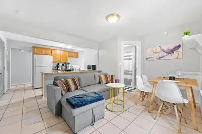 a living room with a couch and a table and a kitchen at Little Italy Group Stay 4 TV's Pet Friendly in Cleveland
