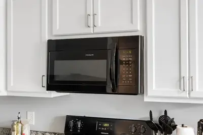 a black microwave above a stove in a kitchen at DT Pet Friendly Parking Gym Wifi Coffee in Cleveland