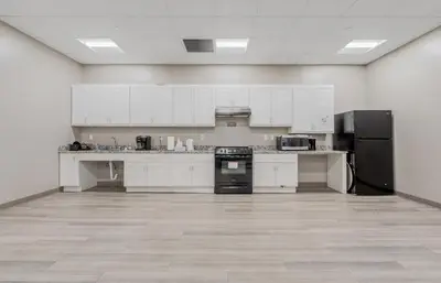 a large kitchen with white cabinets and black appliances at DT Pet Friendly Parking Gym Wifi Coffee in Cleveland