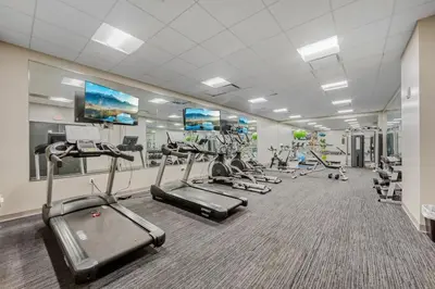 a gym with several treadmills and cardio machines at DT Pet Friendly Parking Gym Wifi Coffee in Cleveland