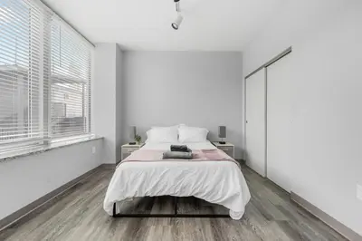a white bedroom with a bed and a window at DT Pet Friendly Parking Gym Wifi Coffee in Cleveland