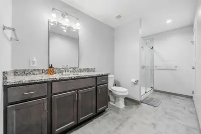 a bathroom with a sink and a toilet and a mirror at DT Pet Friendly Parking Gym Wifi Coffee in Cleveland