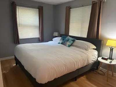 a large bed in a bedroom with two windows at Westdale in Cleveland