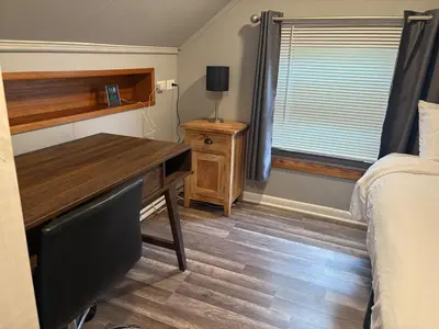 a bedroom with a desk and a bed and a window at Westdale in Cleveland