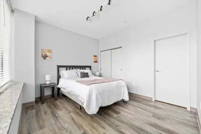 a white bedroom with a large bed and wooden floors at DT Fast Wifi Pet Friendly Bidet Sprayer in Cleveland