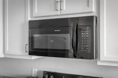 a microwave above a kitchen counter with white cabinets at DT Fast Wifi Pet Friendly Bidet Sprayer in Cleveland