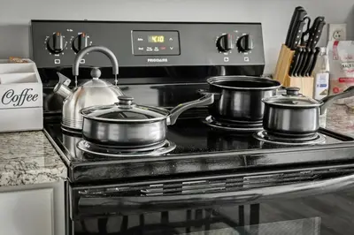 three pots and pans sitting on top of a stove at DT Gym Pet Friendly 1 Bus to Clinic or CSU in Cleveland