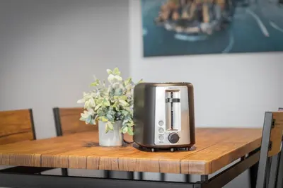a toaster sitting on a table with a vase of flowers at DT Gym Pet Friendly 1 Bus to Clinic or CSU in Cleveland