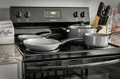 two pots and pans sitting on a stove top at DT Gym Pet Friendly 1 Bus to Clinic or CSU in Cleveland