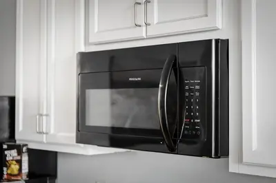a black microwave oven hanging on a kitchen cabinets at DT Gym Pet Friendly 1 Bus to Clinic or CSU in Cleveland