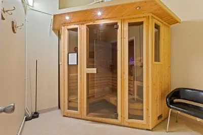 a wooden cabinet in a room with a chair at Spacious Downtown Loft Bunkbeds 2 TVs Gym in Cleveland