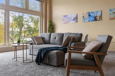 a living room with a couch and a chair at Spacious Downtown Loft Bunkbeds 2 TVs Gym in Cleveland