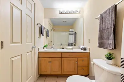 a bathroom with a sink and a toilet and a mirror at Spacious Downtown Loft Bunkbeds 2 TVs Gym in Cleveland
