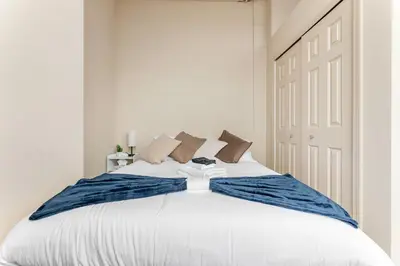 a bedroom with a white bed with a blue bow tie on it at Downtown Gym Sauna Parking Pet Friendly in Cleveland