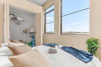 a bedroom with a white bed with a window at Downtown Gym Sauna Parking Pet Friendly in Cleveland