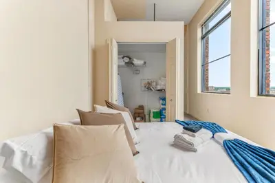 a white bed in a room with a window at Downtown Gym Sauna Parking Pet Friendly in Cleveland