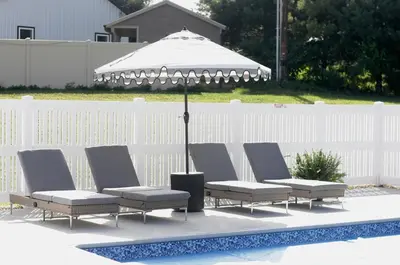 a group of chairs and an umbrella next to a pool at Country Comfort with Pool Family & Groups in Dundee