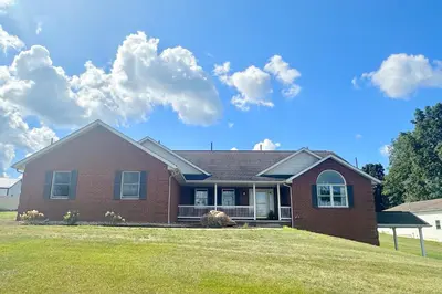 a house on a lawn with clouds in the sky at Country Comfort with Pool Family & Groups in Dundee