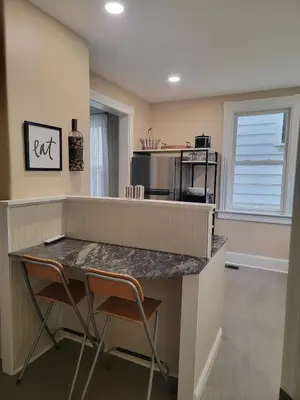a kitchen with a counter and two chairs at a table at 1895 meets 2025 Townhouse in Hamilton