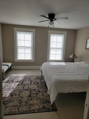 a bedroom with a bed and a ceiling fan at 1895 meets 2025 Townhouse in Hamilton