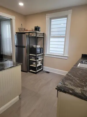 a kitchen with a stainless steel refrigerator and a window at 1895 meets 2025 Townhouse in Hamilton