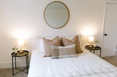 a bedroom with a bed with a mirror on the wall at 