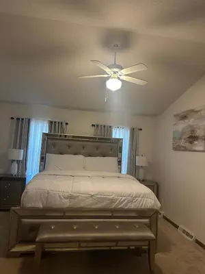 a bedroom with a bed with a ceiling fan at quiet and comfortable in Cleveland