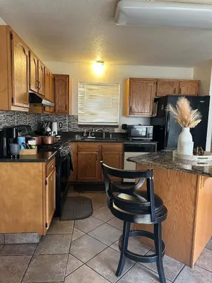 a kitchen with wooden cabinets and a black refrigerator at quiet and comfortable in Cleveland