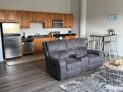 a living room with a couch and a kitchen at Spacious Condo Minutes to Cedar Point in Sandusky